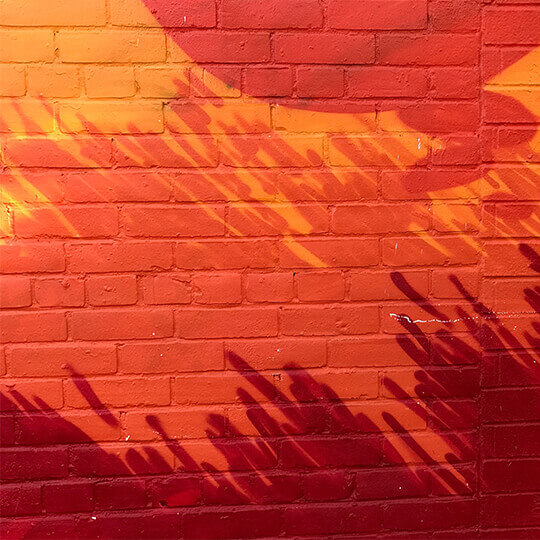 Orange mural on a brick wall