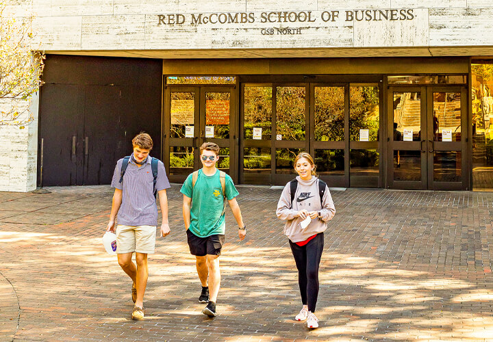 Three students walking out of GSB building