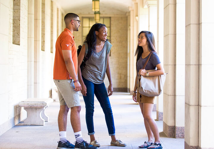 Three students talk together on campus