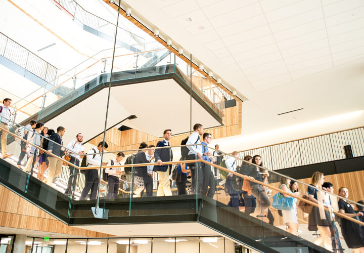 Students descend the stairs in Rowling Hall atrium