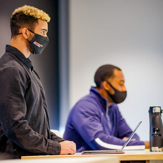 Two masked students in class