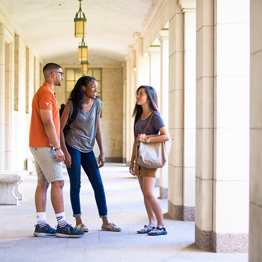 Three students talk together on campus