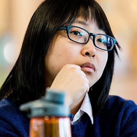 Student with glasses rests head on hand