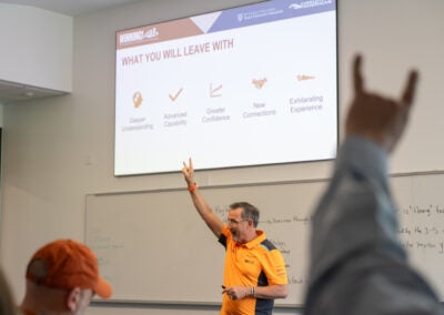 Class participant and lecturer giving Hook 'Em Horns
